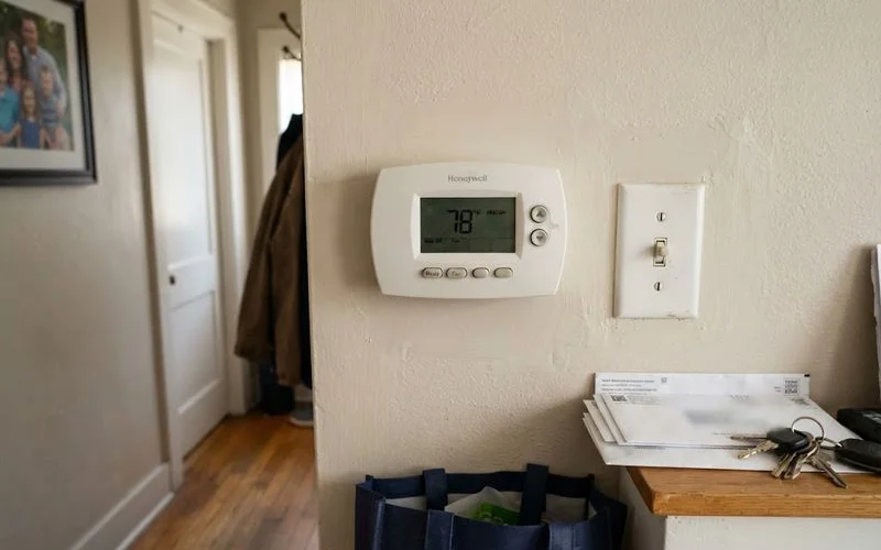 A thermostat display showing a high indoor temperature reading inside a Phoenix home during an AC outage